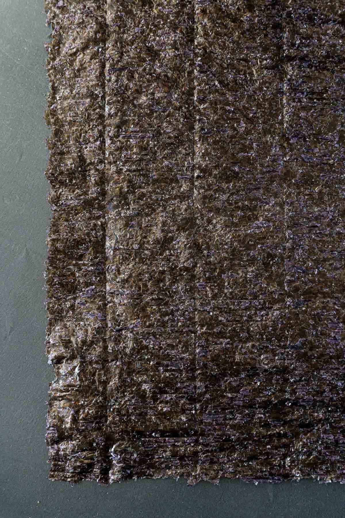 Nori sushi sheet on a grey background.