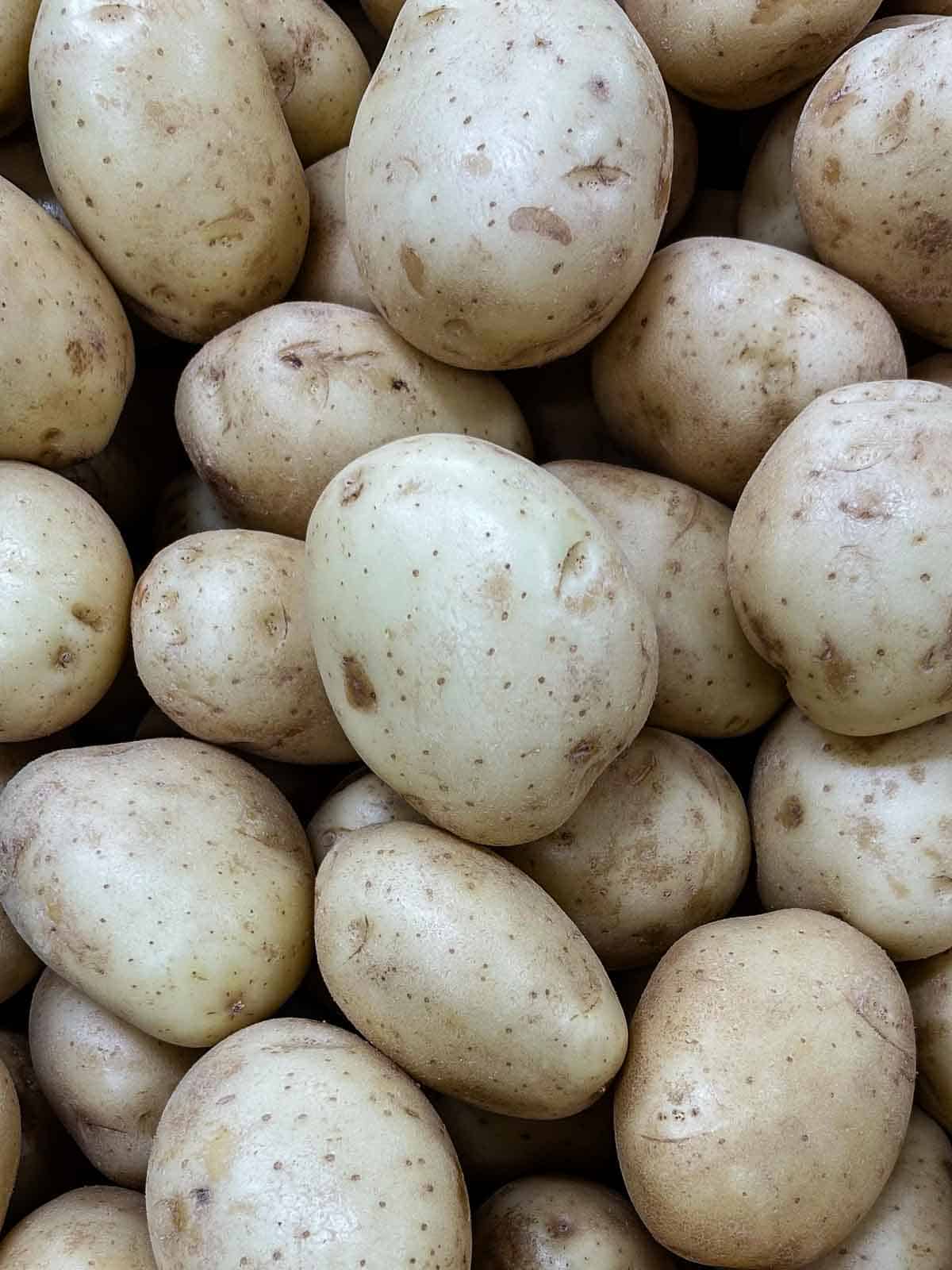 A bunch of pale white potatoes, still raw.