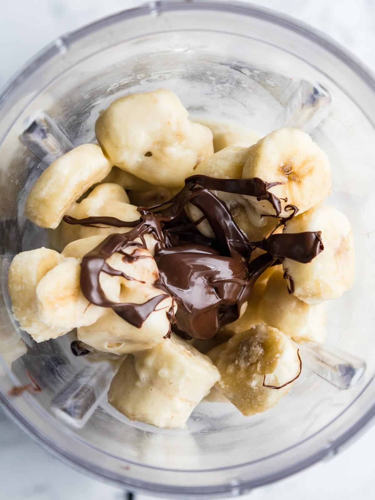 Frozen banana with vegan Nutella in a blender.