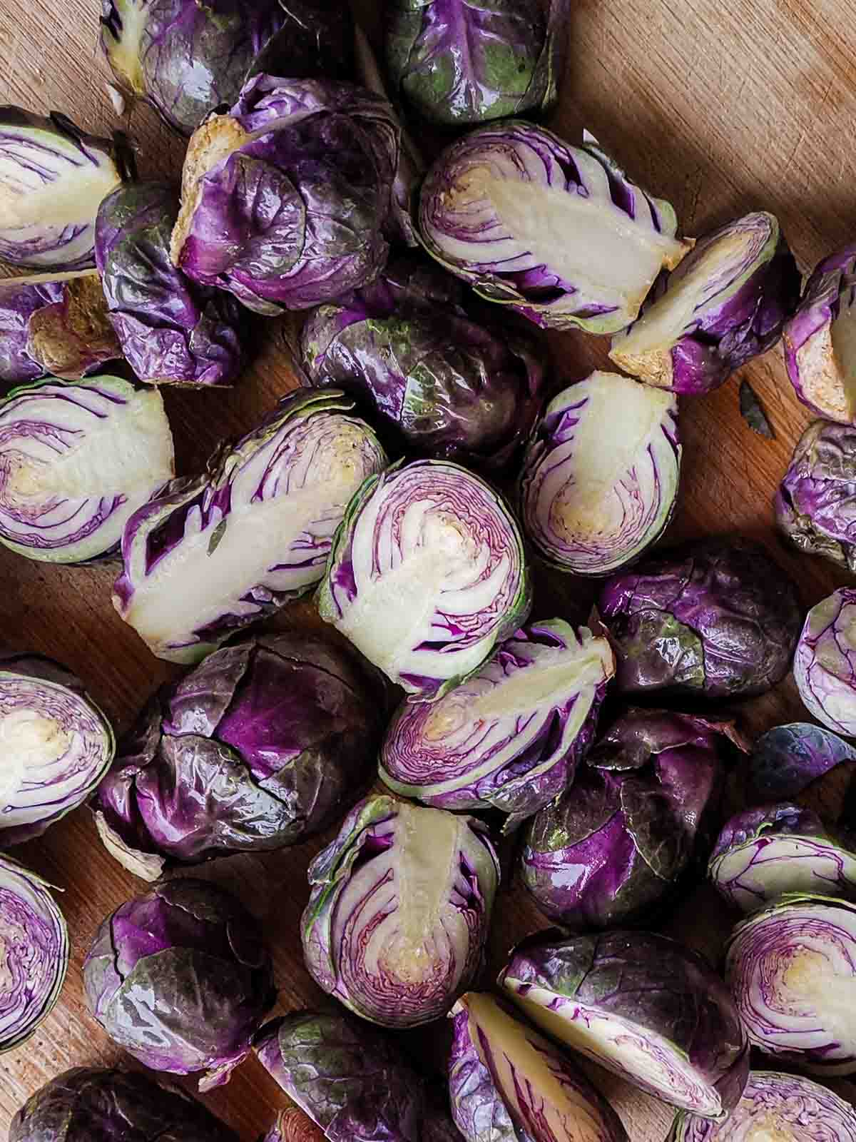 A bunch of purple Brussels sprouts cut open to show the inside.
