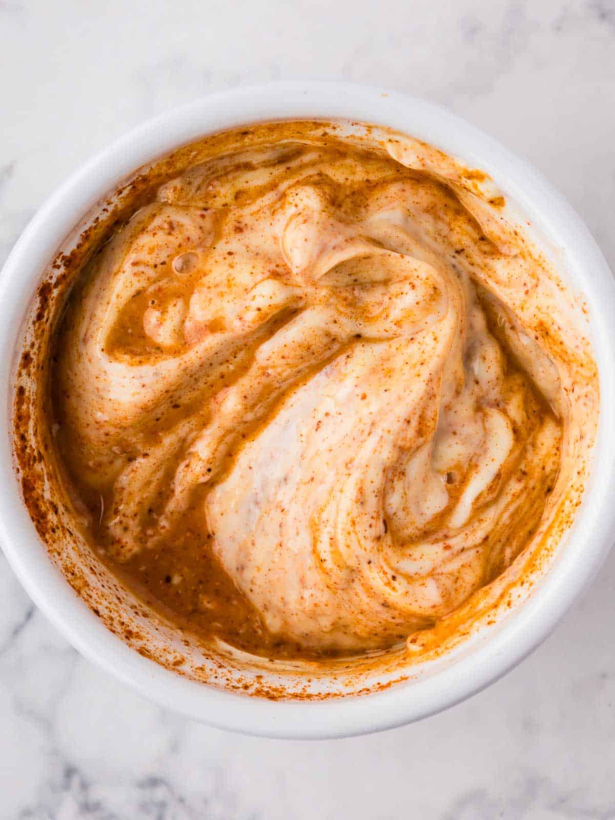 Marbled look of garlic chili aioli as it is being mixed.