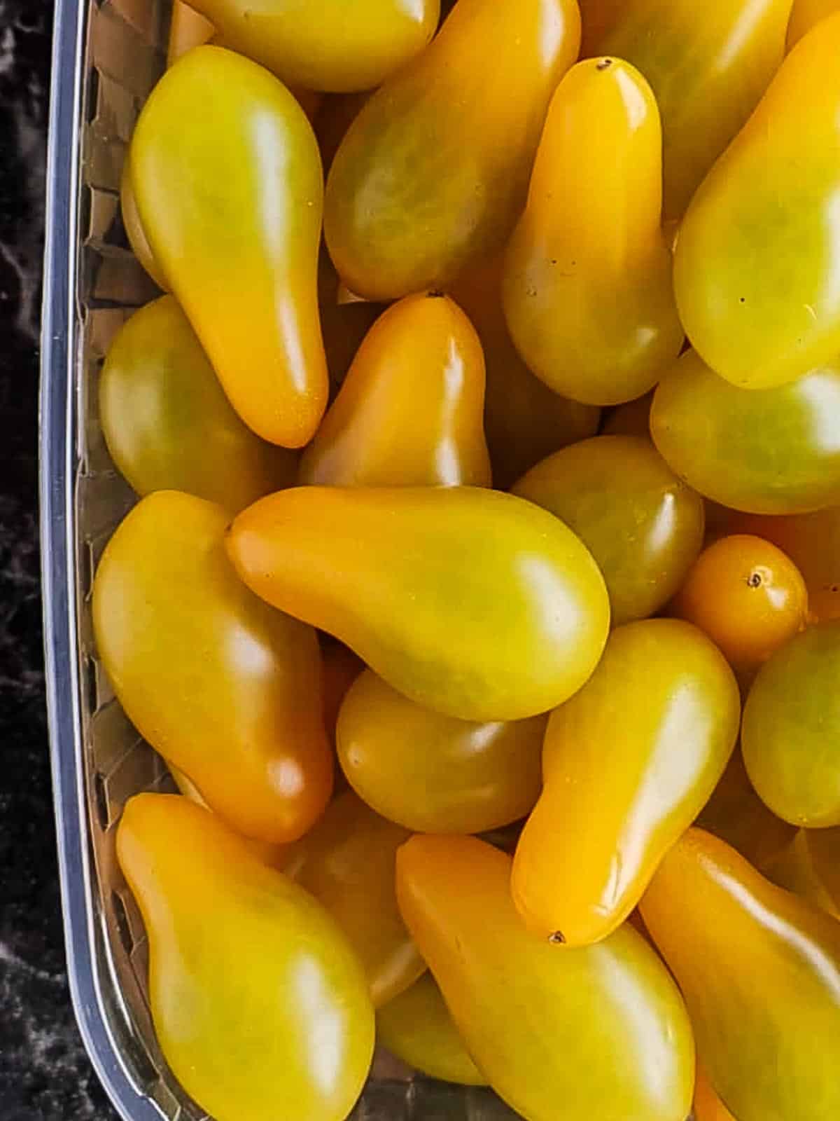 A bunch or small pear-shaped orange tomatoes.