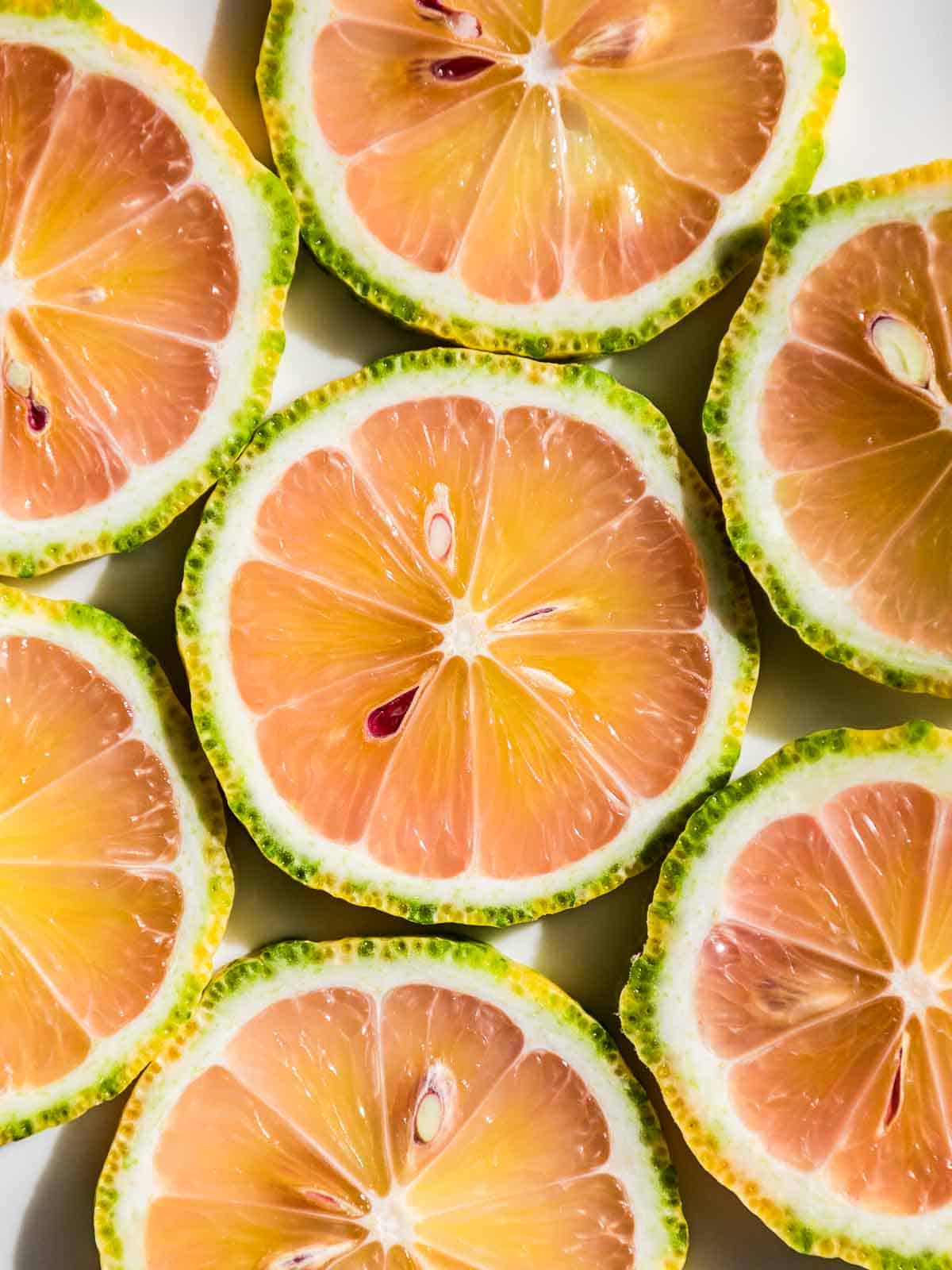 Slices of pink lemons on a white background.