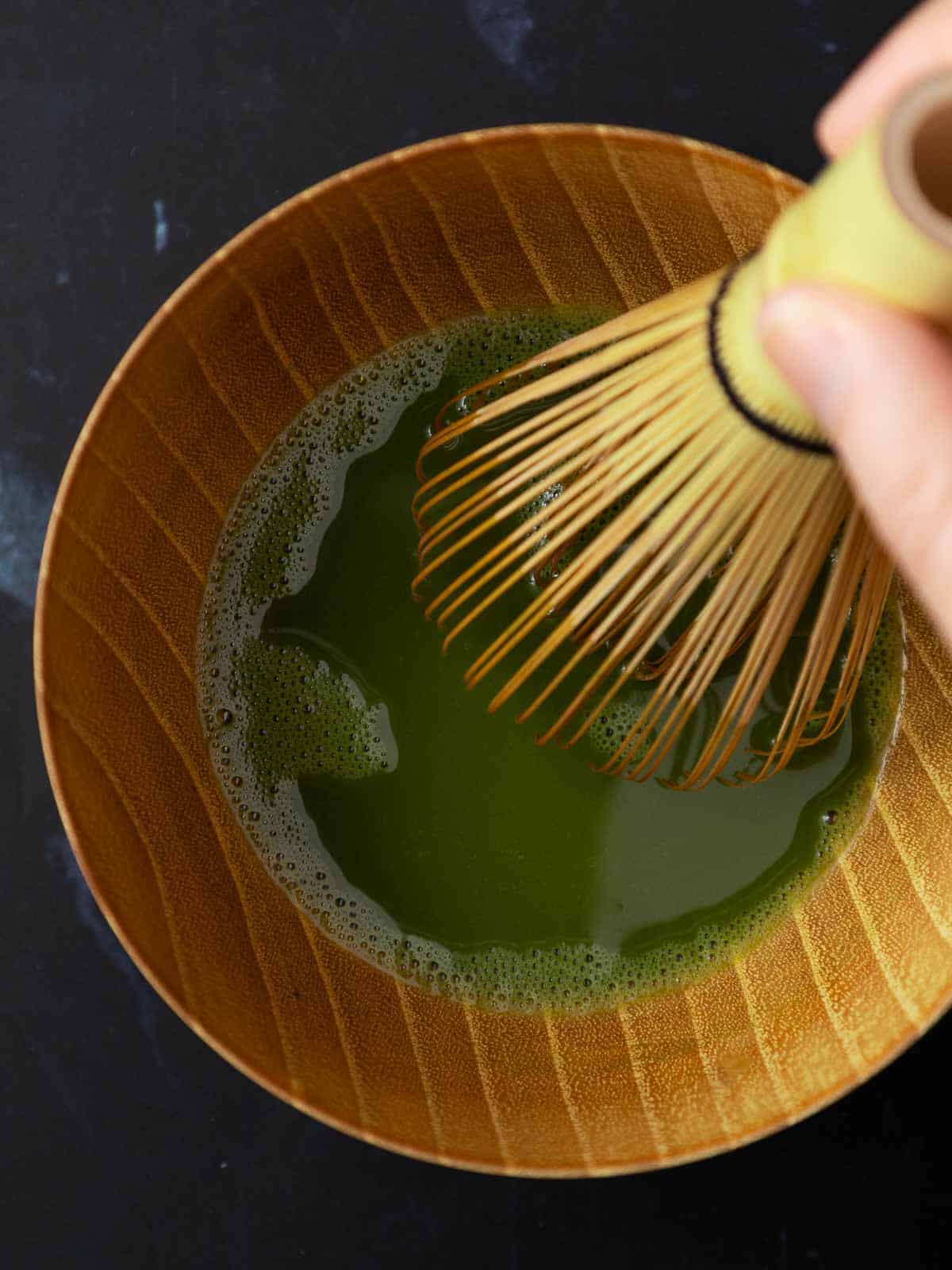 Whisking matcha using chasen (bamboo matcha whisk).