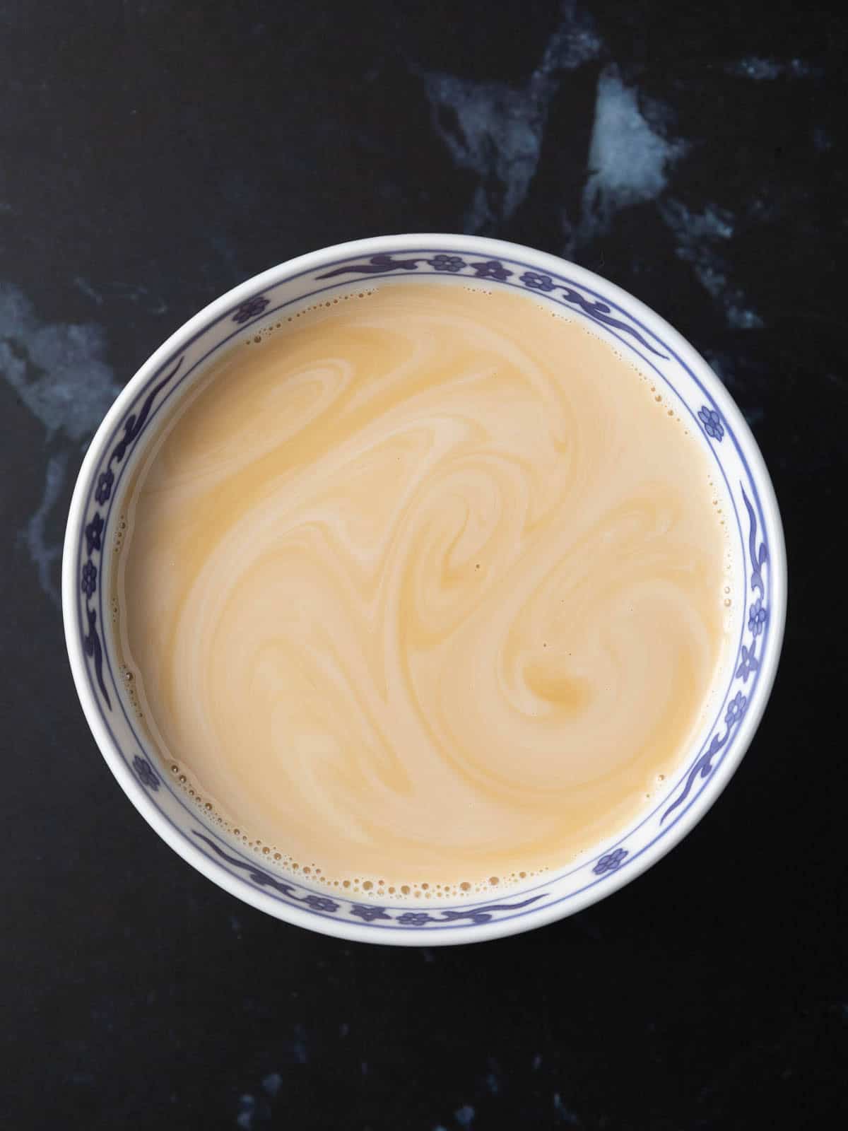 A bowl of plant-based milk with vanilla extract mixed in.
